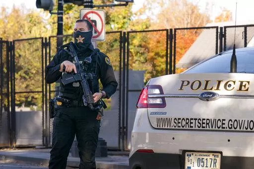 A U.S. Secret Service officer takes a position in the street as President Donald Trump's motorcade arrives at the White House after golfing at his Trump National Golf Club in Sterling, Va., in Washington, Nov. 8, 2020, a day after was defeated by President-elect Joe Biden.  The National Archives has requested a probe of “the potential unauthorized deletion” of text messages the Secret Service sent and received around the attack on the U.S. Capitol on Jan. 6, 2021.  (AP Photo/J. Scott Applewh