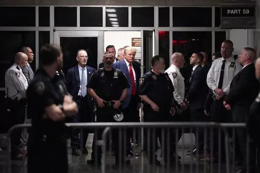 Former President Donald Trump is escorted to a courtroom, April 4, 2023, in New York. A federal judge has rejected Donald Trump's bid to move his hush-money criminal case from New York state court to federal court. He ruled that the former president had failed to meet a high legal bar for changing jurisdiction. (AP Photo/Mary Altaffer, File)