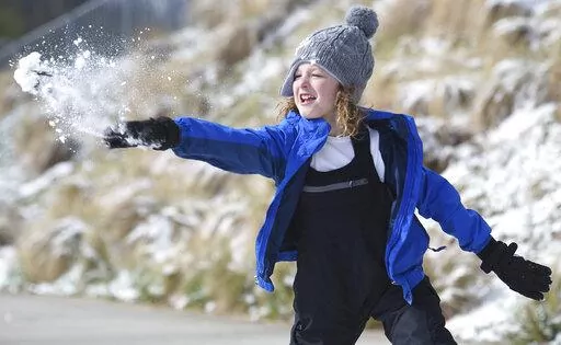 Ian Mattson, 9, throws a snowball at his sister Elise, 5, as they play in Renaissance Park on Saturday, March 12, 2022 In Chattanooga, Tenn.  (Matt Hamilton /Chattanooga Times Free Press via AP)