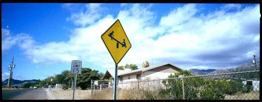 A "playground ahead" warning stands by the side of a road on the outskirts of Bisbee, Ariz., Oct. 26, 2021. Bisbee was home to Paul and Leizza Adams, and their six children, before Paul and Leizza were charged with child sexual abuse. (AP Photo/Dario Lopez-Mills)