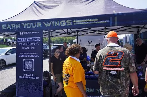 Racing fans stop at the U.S. Air Force recruiting tent prior to a NASCAR race at the New Hampshire Motor Speedway, Sunday, July 17, 2022, in Loudon, N.H. These are tough times for military recruiters.  All services are having problems finding young people who want to join and can meet the physical, mental and moral requirements.  Recruiters are offering bigger bonuses and other incentives to those who sign up. And they are seizing on the boost that Hollywood may offer – such as the buzz over