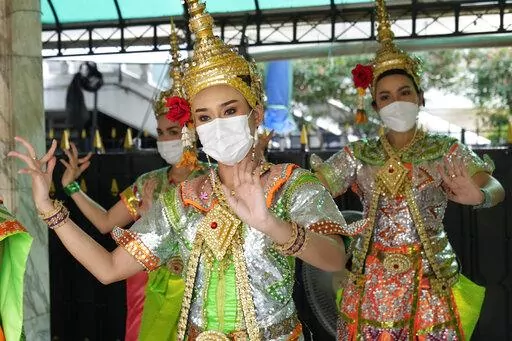 Thai classical dancers wearing face masks to help protect themselves from the coronavirus perform at the Erawan Shrine in Bangkok, Thailand, Monday, Feb. 7, 2022. (AP Photo/Sakchai Lalit)