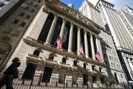 A pedestrian walks past the New York Stock Exchange, Monday, Jan. 24, 2022, in New York.  Stocks are falling in early trading on Wall Street Friday, April 29, putting major indexes back into the red for the week after several sharp moves both up and down.  (AP Photo/John Minchillo, File)
