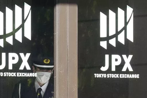 A security guard stands guard at the entrance of the Tokyo Stock Exchange building Wednesday, Nov. 2, 2022, in Tokyo. Asian shares were mostly higher Wednesday ahead of a decision by the U.S. Federal Reserve on an interest rate increase to curb inflation. (AP Photo/Eugene Hoshiko)