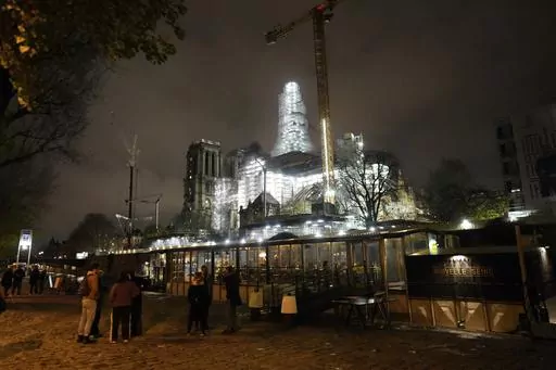 Notre-Dame de Paris cathedral is seen with its spire surrounded by scaffolding Tuesday, Dec. 5, 2023 in Paris. The restoration of Notre Dame hits a milestone Friday, Dec. 8, 2023: one year until the cathedral reopens its huge doors to the public. (AP Photo/Thibault Camus)