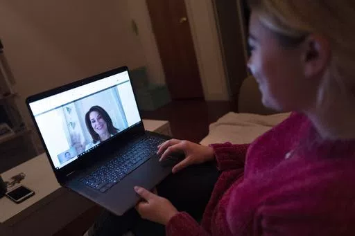 A patient sits in the living room of her apartment in the Brooklyn borough of New York during a telemedicine video conference with a physician on Jan. 14, 2019. Patients can now see an array of doctors without leaving their recliner thanks to telemedicine. But that doesn’t mean trips to the office should end. Finding the right balance between virtual and in-person visits can be a key to getting good care. (AP Photo/Mark Lennihan, File)