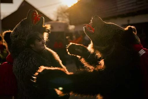 People wearing bear fur costumes prepare to take part in a parade showcasing regional winter traditions in Comanesti, northeastern Romania, Friday, Dec. 30, 2022. Centuries ago, people in what is now northeast Romania would don bear fur and dance to fend off evil spirits. Nowadays, the custom lives on as a popular festival that has been drawing crowds of tourists. The so-called 'dancing bears festival' takes place every December, starting in the days before Christmas and ending with the New Year
