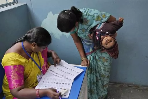 A woman checks for her name before casting her vote at a polling station during the Telangana state assembly elections in Hyderabad, India, Nov. 30, 2023. From April 19 to June 1, nearly 970 million Indians - or over 10% of the world’s population - will vote in the country's general elections. It's one of several high-profile elections around the world this year that are highlighting concerns about online election misinformation. (AP Photo/Mahesh Kumar A., File)