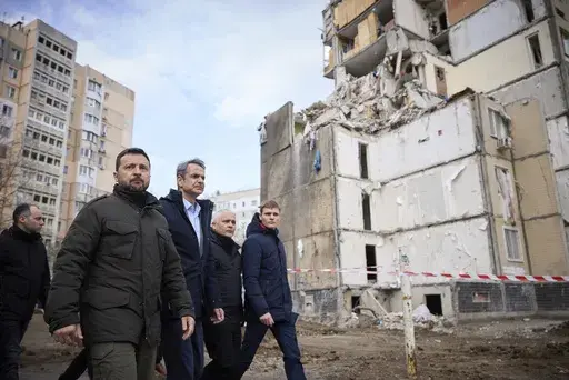 In this photo provided by the Ukrainian Presidential Press Office, Ukrainian President Volodymyr Zelenskyy, second from left, and Greece's Prime Minister Kyriakos Mitsotakis, third from left, walk in a residential area damaged by Russian attack in Odesa, Ukraine, Wednesday, March 6, 2024. The sound of a large explosion reverberated around the Ukrainian port of Odesa as President Volodymyr Zelenskyy and Greece's prime minister ended a tour of the war-ravaged southern city Wednesday. (Ukrainian Pr