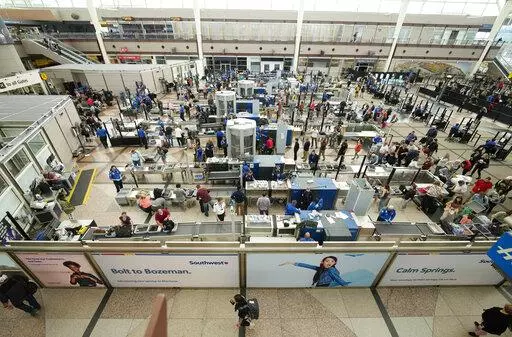 Travelers queue up at the south security checkpoint in the main terminal of Denver International Airport, Thursday, May 26, 2022, in Denver. Experts are expecting a flush of travelers at airports and on the nation's byways during the long Memorial Day weekend, which marks the start of the summer travel season, in spite of high fuel costs. (AP Photo/David Zalubowski)