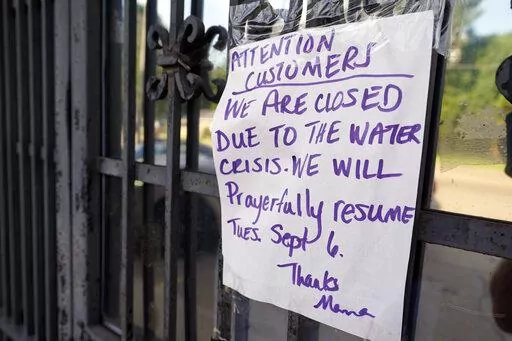 A sign taped to the door of the closed Mama's Eats and Sweets restaurant is one of the casualties of the water crisis Friday Sep. 2, 2022, in Jackson, Miss. (AP Photo/Steve Helber)