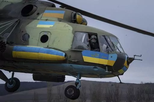 A Ukrainian pilot waves to his comrades from an Mi-8 combat helicopter during a combat mission in Donetsk region, Ukraine, Saturday, March 18, 2023. (AP Photo/Evgeniy Maloletka)