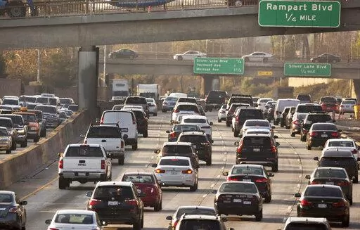 This Dec. 12, 2018, file photo shows traffic on the Hollywood Freeway in Los Angeles. New vehicles sold in the U.S. will have to travel an average of at least 40 miles per gallon of gasoline in 2026 under new rules unveiled by the government. The National Highway Traffic Safety Administration said Friday its fuel economy requirements will undo a rollback enacted under President Donald Trump. (AP Photo/Damian Dovarganes, File)
