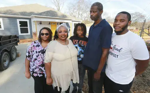 Members of the Garth family, from left, Alexandria Copeland, Nicole garth, Jahree Garth, Jari Garth and Jonavon Edwards, stands outside their new home in Tupelo, Miss. on Dec. 15, 2021. The Garths built the home with the help of the Northeast Mississippi Habitat for Humanity. It's the groups second finished home of the year. (Thomas Wells/The Northeast Mississippi Daily Journal via AP)