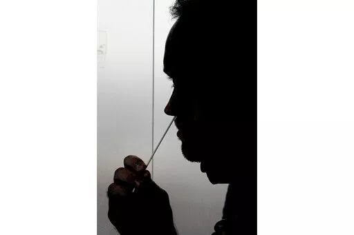 FILE - A rapid COVID-19 test is taken, Wednesday, Nov. 18, 2020, in Salt Lake City. President Joe Biden says the federal government will buy half a billion COVID-19 rapid test kits and distribute them free of charge to people to use at home. Delivery of the first batch of the 500 million tests isn't expected until early January 2022. (AP Photo/Rick Bowmer, File)