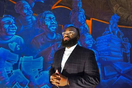 Pastor Aaron Marble stands in front of a mural in the historically black community of North Nashville, Friday, Feb.11, 2022, in Nashville, Tenn. The area is being combined into a mostly white congressional district, a move Marble believes will unfairly affect black voters. (AP Photo/John Amis)