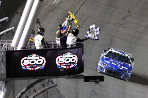 Ricky Stenhouse Jr. takes the checkered flag to win the NASCAR Daytona 500 auto race at Daytona International Speedway, Sunday, Feb. 19, 2023, in Daytona Beach, Fla. (AP Photo/David Graham)