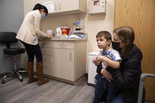 Ilana Diener holds her son, Hudson, 3, during an appointment for a Moderna COVID-19 vaccine trial in Commack, N.Y. on Nov. 30, 2021. On Thursday, April 28, 2022, Moderna asked U.S. regulators to authorize low doses of its COVID-19 vaccine for children younger than 6, a long-awaited move toward potentially opening shots for millions of tots by summer. (AP Photo/Emma H. Tobin, File)