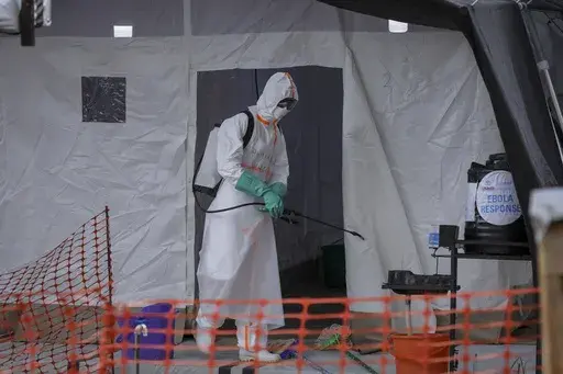 A medical worker disinfects a tent used for suspected Ebola victims inside the Ebola isolation center of Madudu Health Center III, in the village of Madudu, in the Mubende district of Uganda Tuesday, Nov. 1, 2022. (AP Photo/Hajarah Nalwadda, File)