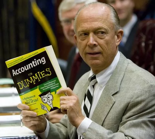 South Carolina Comptroller General Richard Eckstrom holds up a book he wanted to present to his new Chief of Staff James Holly during his introduction at the Budget and Control Board meeting, Aug. 13, 2009, in Columbia, S.C. Pressure is mounting for Eckstrom after a $3.5B accounting error. (AP Photo/Mary Ann Chastain, File)