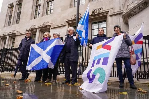 Scottish flags are held by demonstrators, outside the Supreme Court, in London, Wednesday, Nov. 23, 2022. The U.K. Supreme Court ruled Wednesday that Scotland does not have the power to hold a new referendum on independence without the consent of the British government. The judgment is a setback for the Scottish government's campaign to break away from the United Kingdom.(AP Photo/Alberto Pezzali)