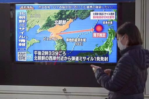 A woman walks along a sidewalk past a TV displaying a news program on North Korea's missile launch Thursday, March 24, 2022, in Tokyo. North Korea has fired a suspected long-range missile toward the sea in what would be its first such test since 2017, raising the ante in a pressure campaign aimed at forcing the United States and other rivals to accept it as a nuclear power and remove crippling sanctions. (AP Photo/Eugene Hoshiko)
