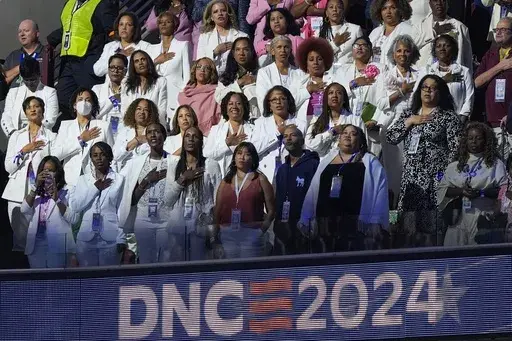 People wear white during the Pleadge of Alliegence during the Democratic National Convention Thursday, Aug. 22, 2024, in Chicago. (AP Photo/Charles Rex Arbogast)