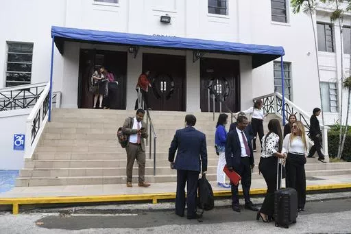 Lawyers and court workers leave the Supreme Court during a recess for the trial of the "Panama Papers" money laundering case in Panama City, Monday, April 8, 2024. (AP Photo/Agustin Herrera)